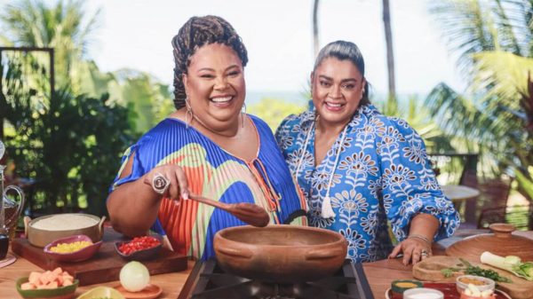 Preta Gil e a influenciadora apresentadora do "Uma Senhora Panela" posam em frente a uma panela